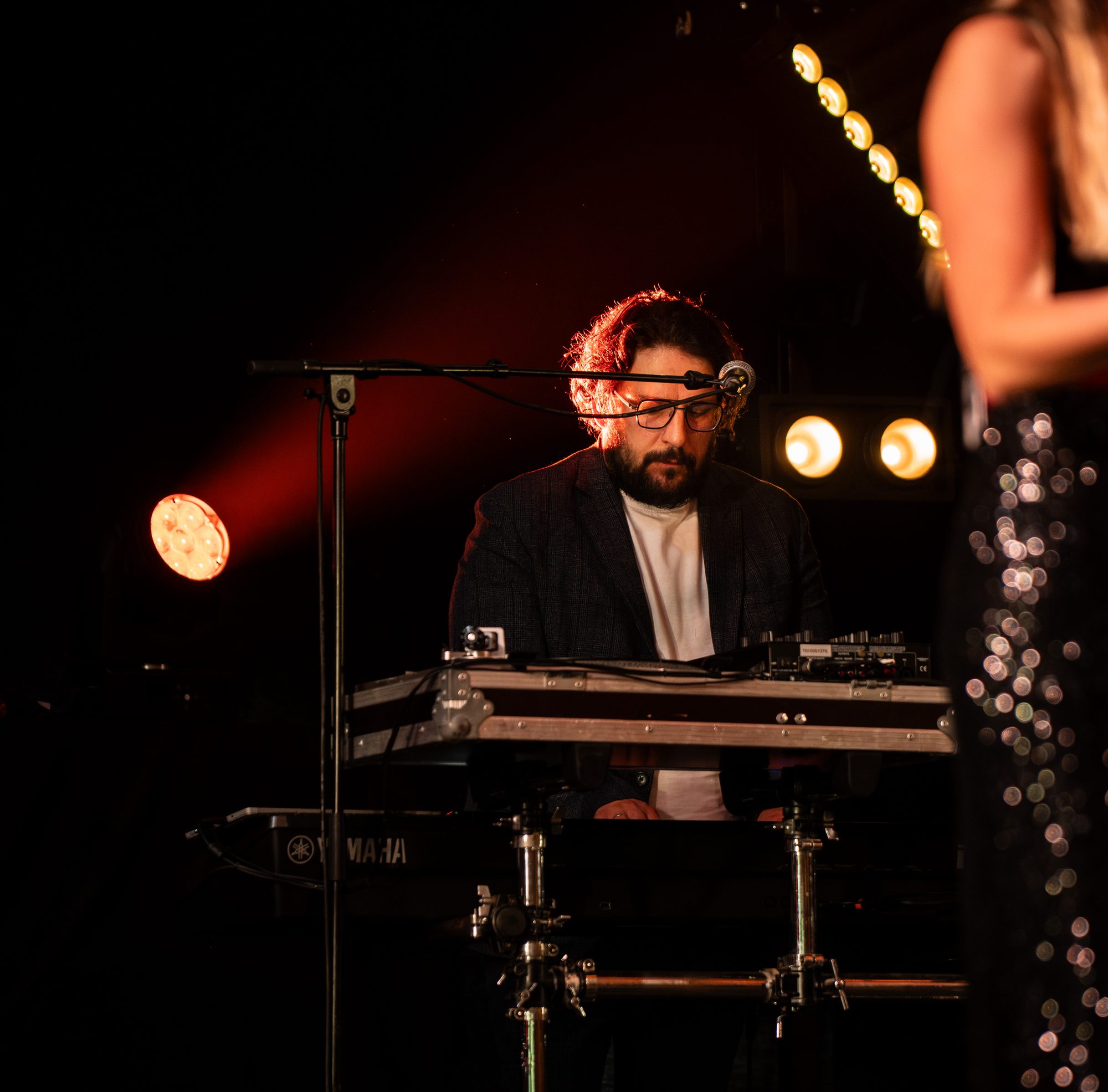 Numéro de danse cabaret sous les lumières rouges de la soirée des 50 ans du Super U de Pipriac — photo Benjamin VF Photographie